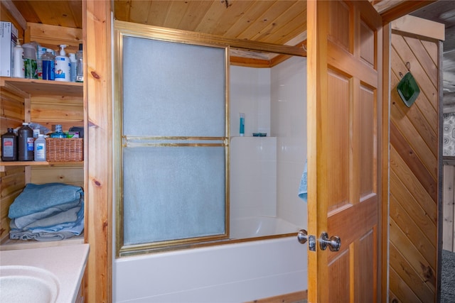 bathroom featuring combined bath / shower with glass door, vanity, wood ceiling, and wood walls