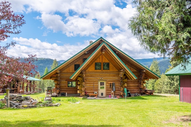 rear view of property featuring a mountain view and a yard