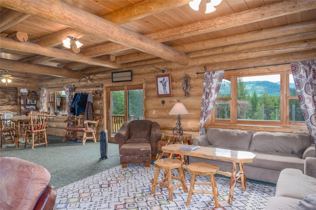 carpeted living room with beam ceiling, plenty of natural light, log walls, and wooden ceiling