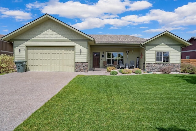 view of front of house featuring a garage, stone siding, driveway, and a front yard