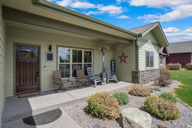 doorway to property with stone siding and a porch