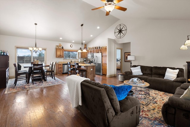 living room with high vaulted ceiling, recessed lighting, dark wood finished floors, and ceiling fan with notable chandelier