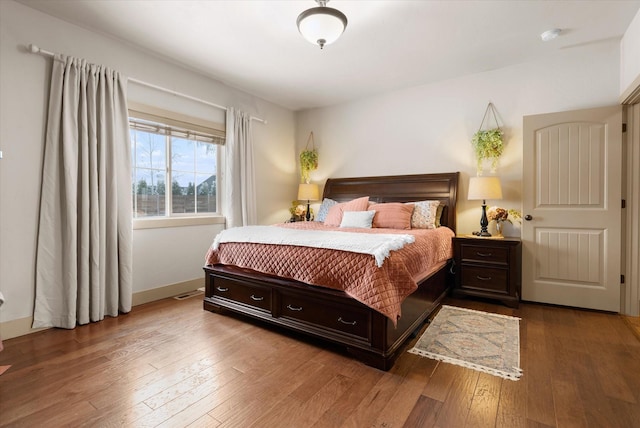 bedroom featuring baseboards and hardwood / wood-style flooring