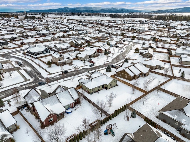 snowy aerial view with a mountain view and a residential view