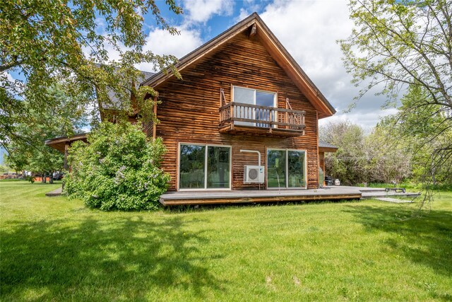 back of property with a yard, a balcony, and a wooden deck