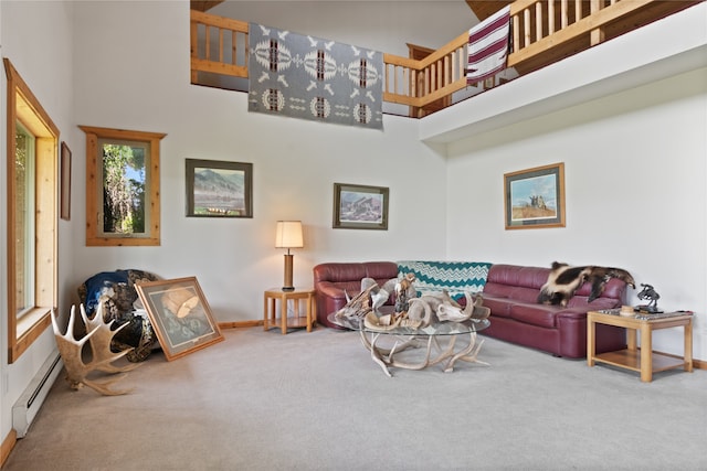 carpeted living room with baseboard heating and a high ceiling