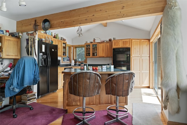 kitchen featuring a kitchen breakfast bar, vaulted ceiling with beams, light wood-type flooring, black appliances, and a center island