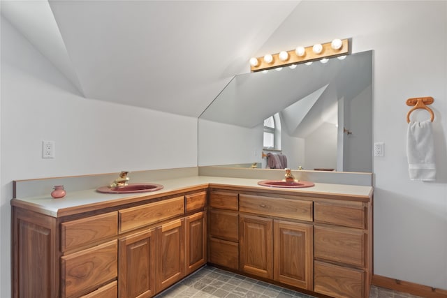 bathroom with vaulted ceiling, tile flooring, and vanity