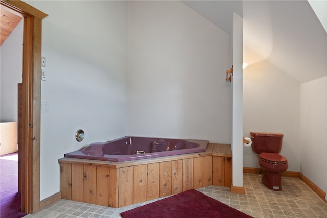 bathroom with a washtub, toilet, and tile floors