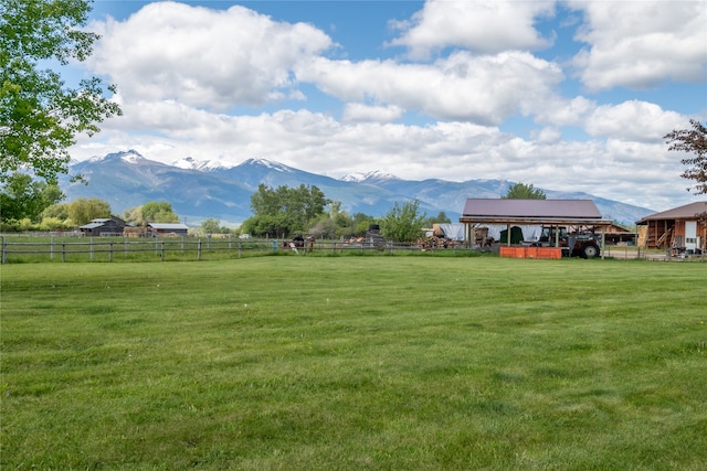 view of yard with an outdoor structure, a mountain view, and a rural view