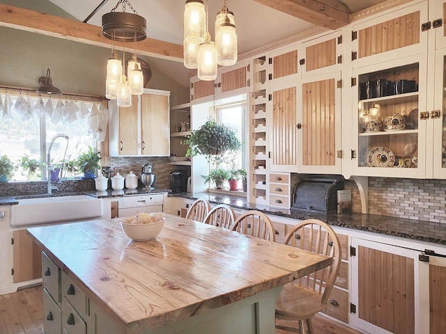 kitchen featuring a breakfast bar area, light hardwood / wood-style floors, tasteful backsplash, and a center island