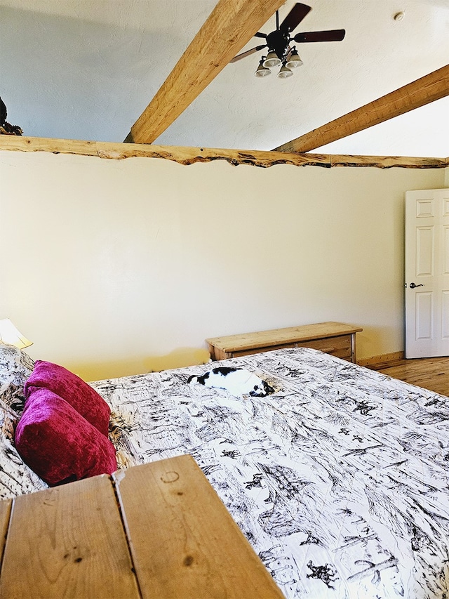 bedroom featuring lofted ceiling with beams, wood-type flooring, and ceiling fan