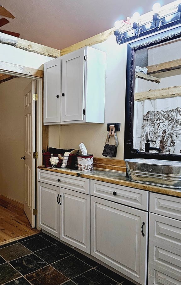 kitchen with white cabinetry and dark tile patterned flooring