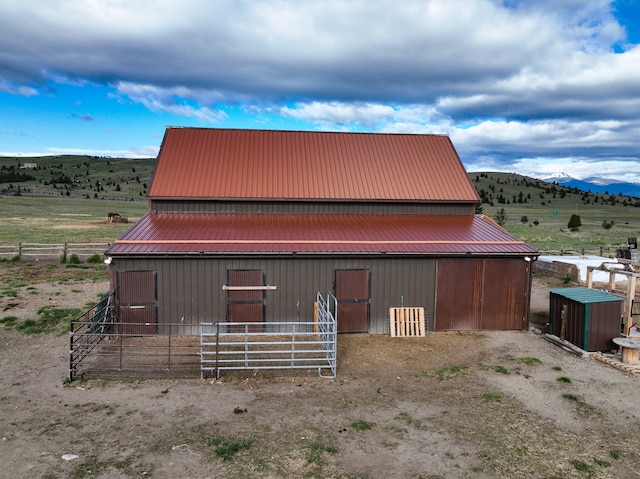 view of front facade featuring a mountain view, an outbuilding, and a rural view