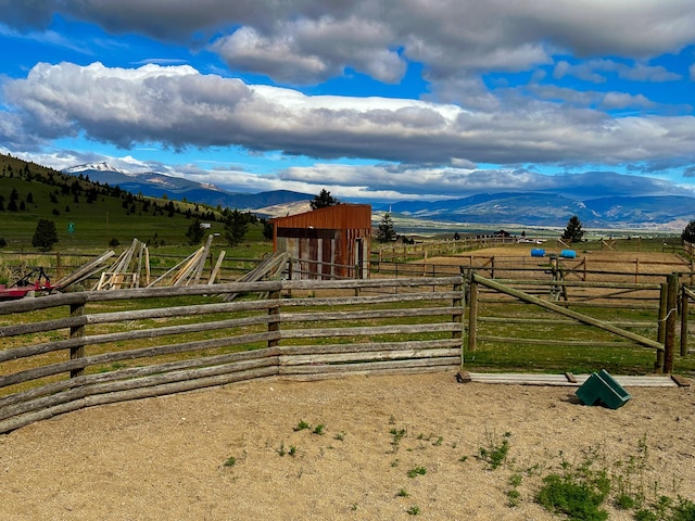 view of horse barn with a mountain view, a rural view, and an outdoor structure