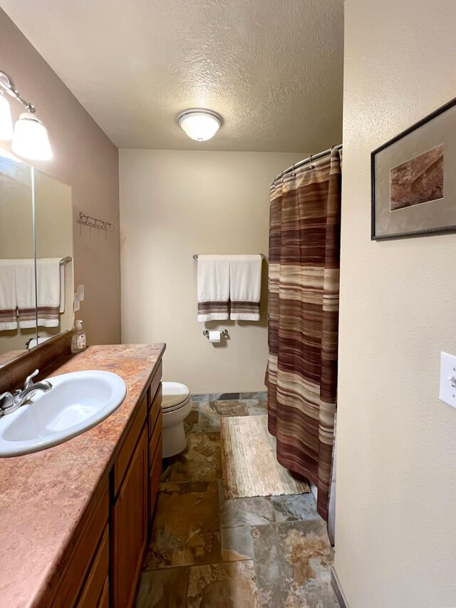 clothes washing area featuring a textured ceiling, washer and clothes dryer, and sink