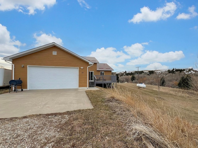 view of front of house featuring a garage, a wooden deck, and driveway