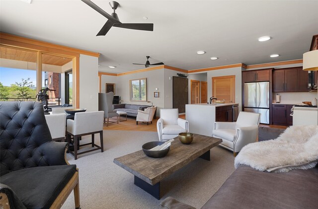 living room with hardwood / wood-style floors, sink, ornamental molding, and ceiling fan