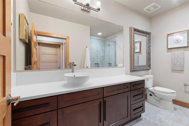 bathroom featuring vanity, toilet, and a shower with shower door