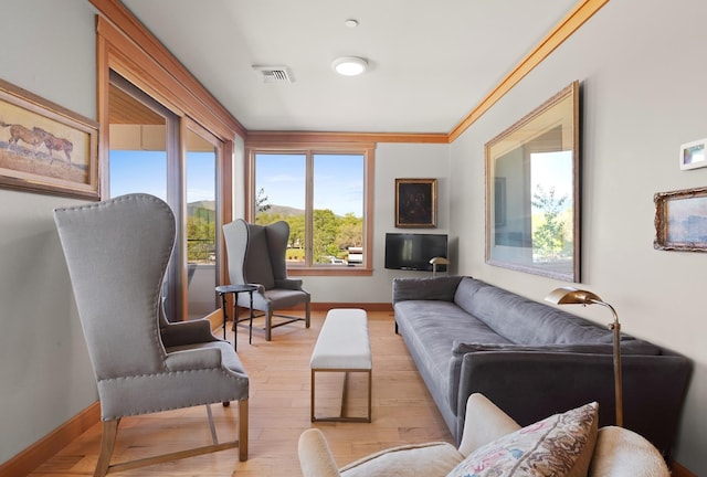 living room featuring ornamental molding and light hardwood / wood-style floors