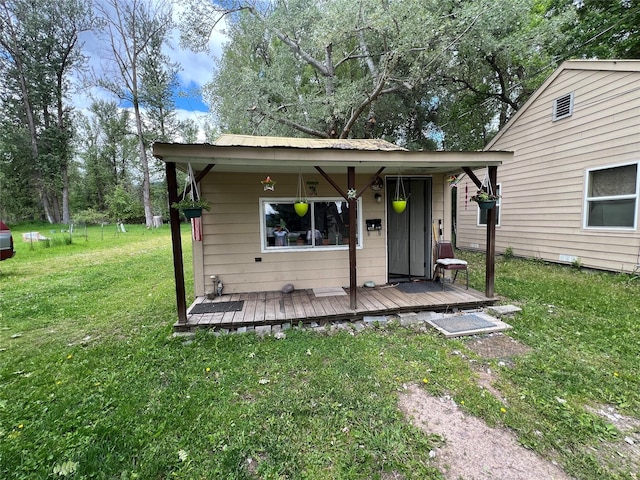 rear view of house featuring a yard and a wooden deck