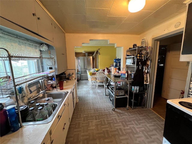 kitchen featuring cooktop, dark parquet floors, white cabinets, and white electric range