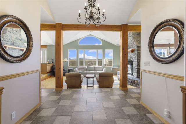 tiled entrance foyer featuring a notable chandelier and vaulted ceiling