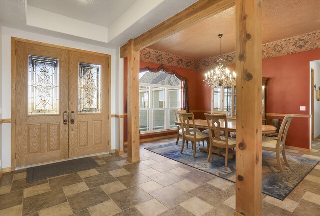 dining space featuring an inviting chandelier, tile flooring, and a tray ceiling