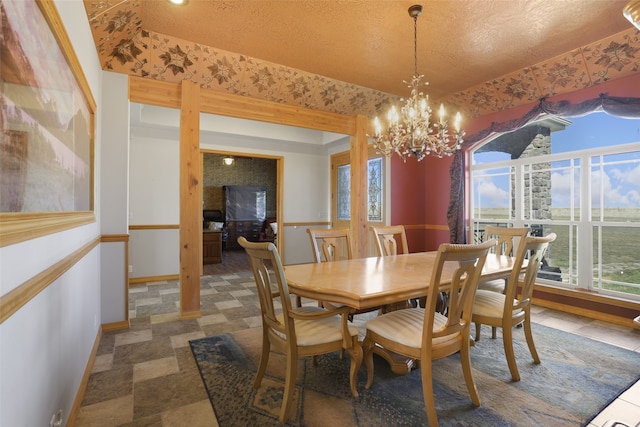 tiled dining space featuring a notable chandelier and a textured ceiling