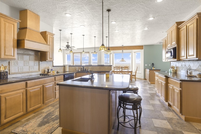 kitchen with hanging light fixtures, a center island with sink, custom range hood, a breakfast bar, and tasteful backsplash