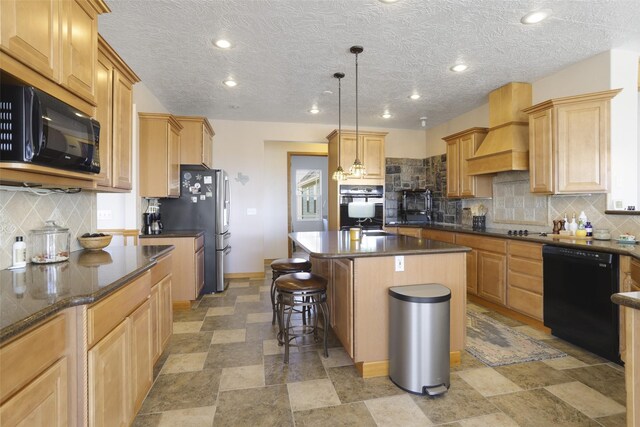 kitchen featuring a center island, black appliances, tasteful backsplash, and custom exhaust hood