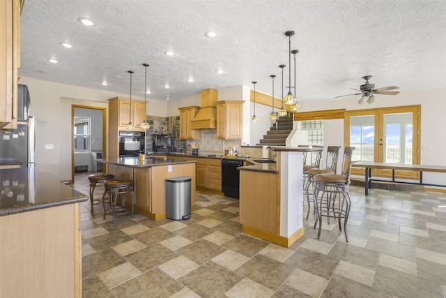 1030 Sun River Cascade Rd, Sun River, MT 59483 - kitchen with a sink, a kitchen breakfast bar, dark countertops, and black appliances
