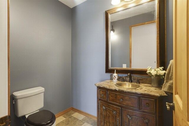 bathroom featuring vanity, toilet, and tile floors