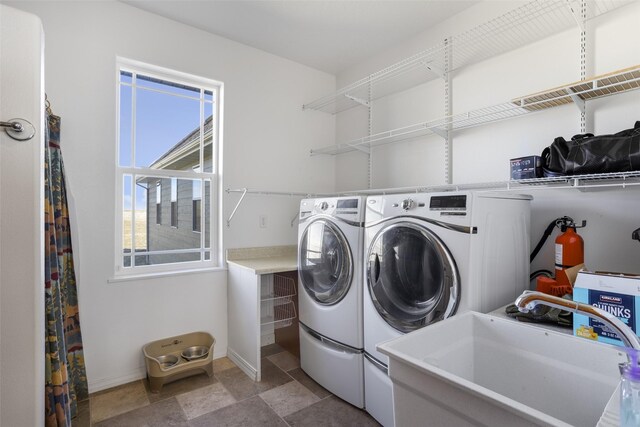 clothes washing area with sink, tile flooring, and washer and clothes dryer