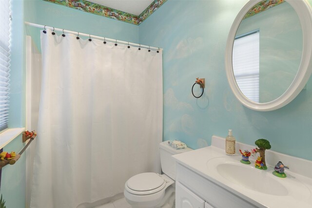 bathroom featuring vanity with extensive cabinet space and toilet