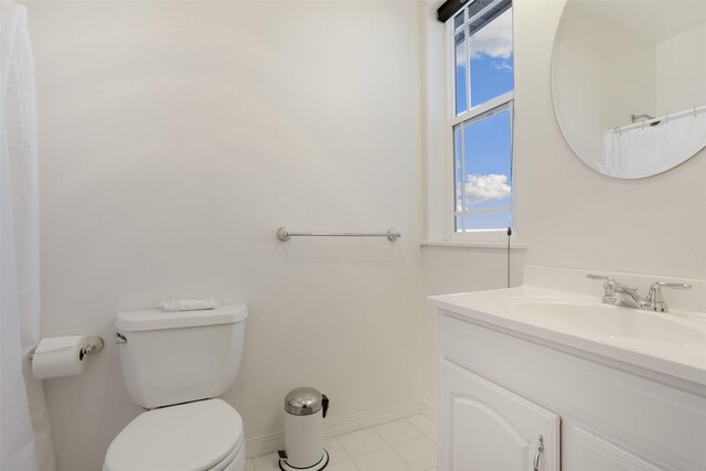 bathroom featuring tile flooring, vanity with extensive cabinet space, and toilet