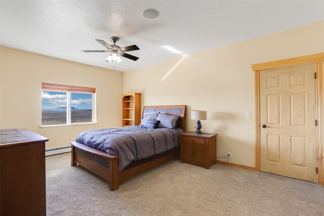 carpeted bedroom with a baseboard radiator and ceiling fan