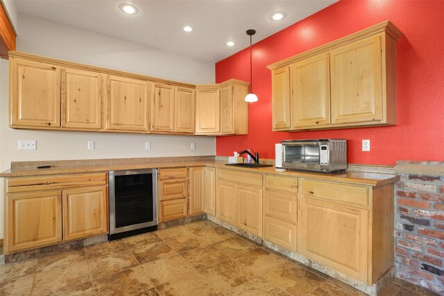 kitchen featuring light brown cabinets, wine cooler, light tile flooring, hanging light fixtures, and sink