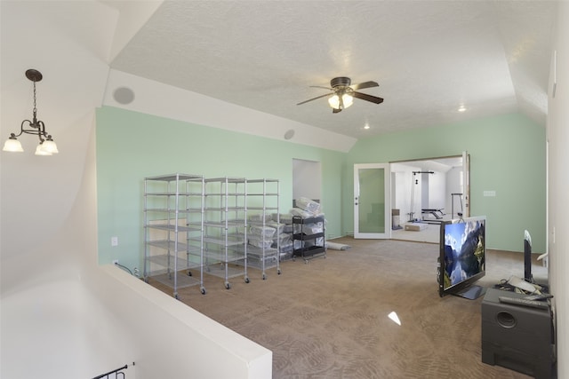 office space featuring carpet, lofted ceiling, a textured ceiling, and ceiling fan with notable chandelier