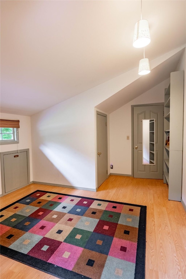 interior space featuring light wood-type flooring and lofted ceiling