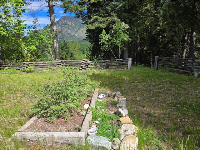 view of yard featuring fence and a mountain view