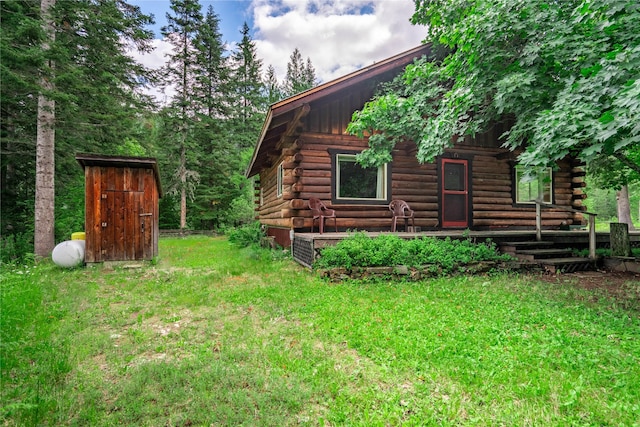 view of side of property featuring log exterior and a yard