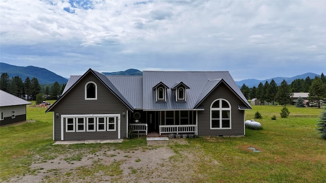 rear view of house with a lawn, a mountain view, and covered porch