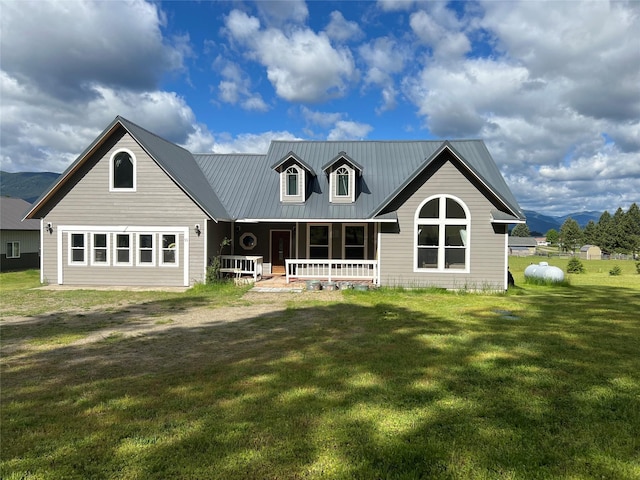 back of house with covered porch, a yard, and a mountain view