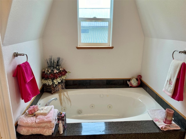 bathroom with vaulted ceiling and a bathing tub