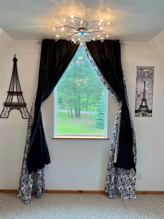 carpeted spare room featuring lofted ceiling and a textured ceiling