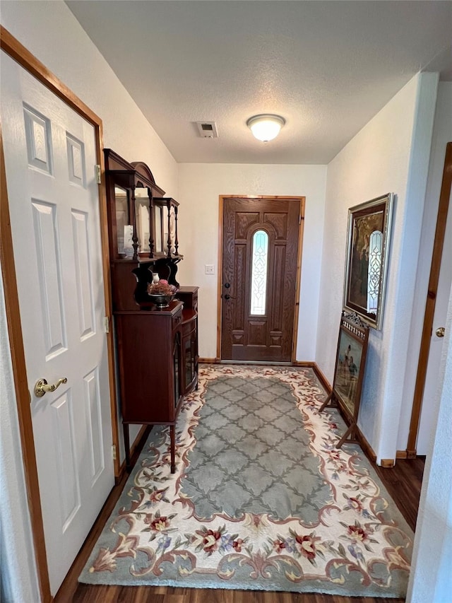 foyer entrance featuring wood-type flooring and a textured ceiling