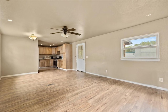 unfurnished living room featuring light hardwood / wood-style flooring and ceiling fan