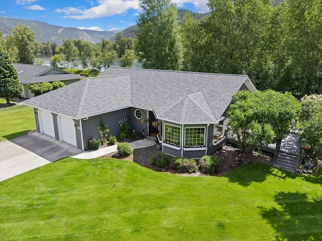 view of front of home featuring a mountain view, a garage, and a front yard