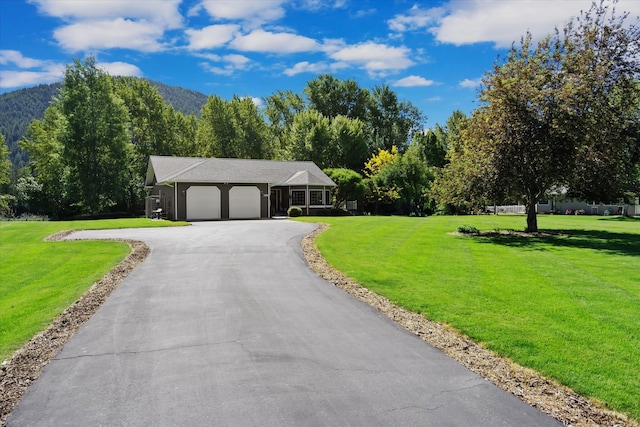 ranch-style house featuring a mountain view, a garage, and a front lawn